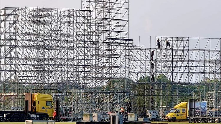 Vrachtwagens met trailers tijdens opbouw van het Layher-podium