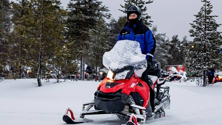 Sneeuwscooter rit door de bossen van Lapland